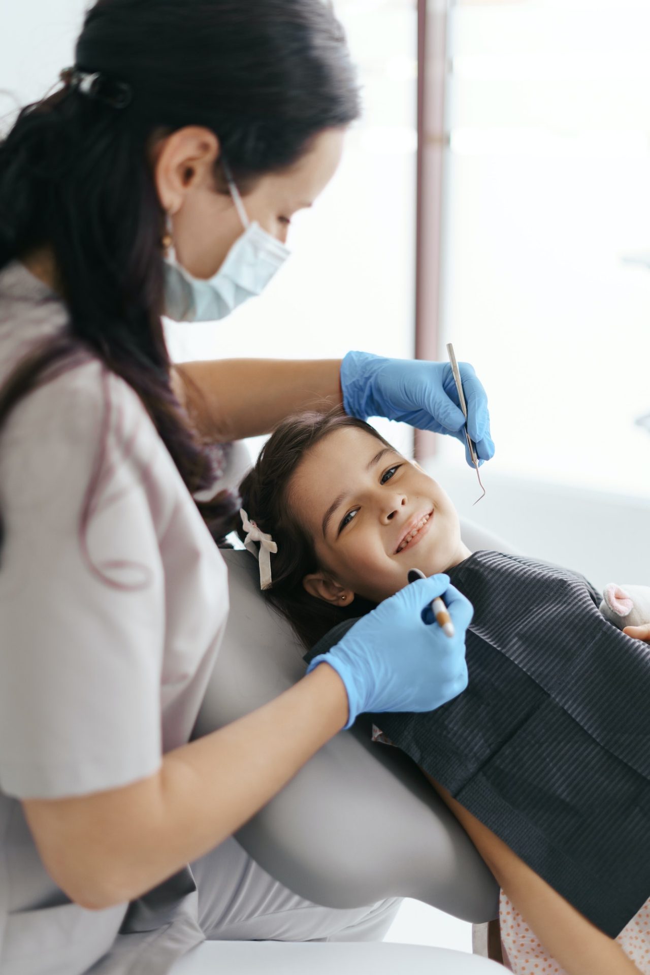 Little beautiful girl at the dentist looking at the camera and smiling