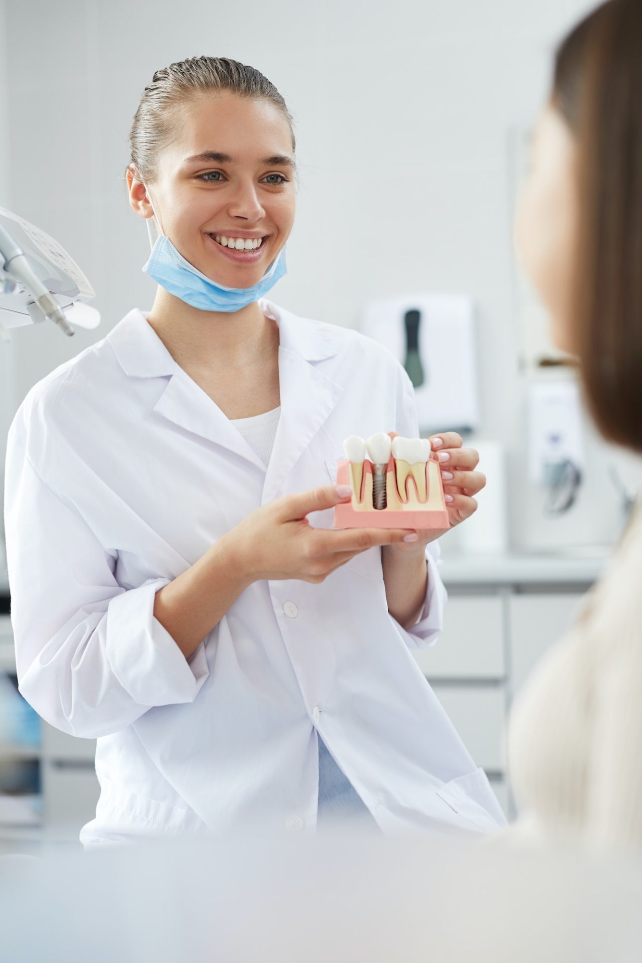 Smiling Dentist Holding Tooth Model